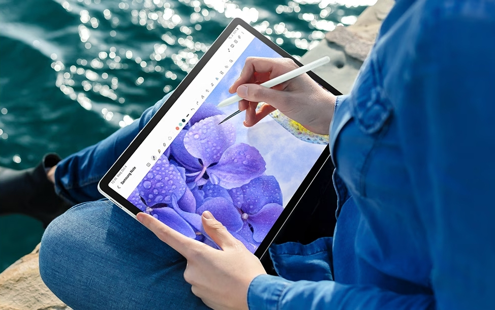 Une personne dessine sur sa tablette samsung galaxy tab s9 fe/fe+ au bord de l'eau